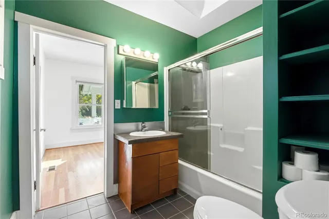a bathroom with a granite countertop sink toilet and shower