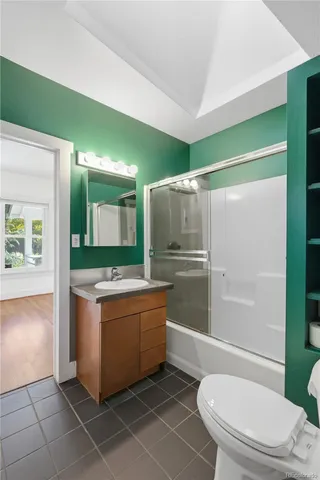 a bathroom with a granite countertop sink mirror vanity and toilet