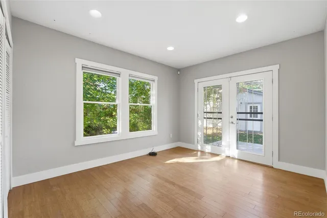 an empty room with wooden floor and windows