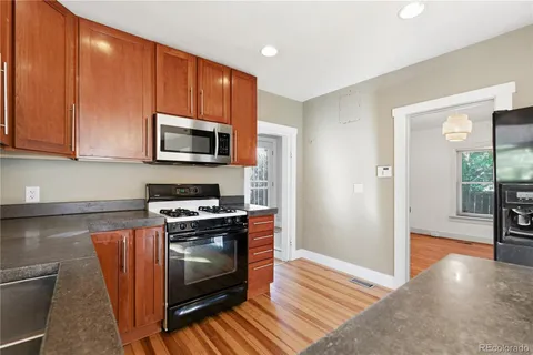 a kitchen with a stove a microwave and cabinets