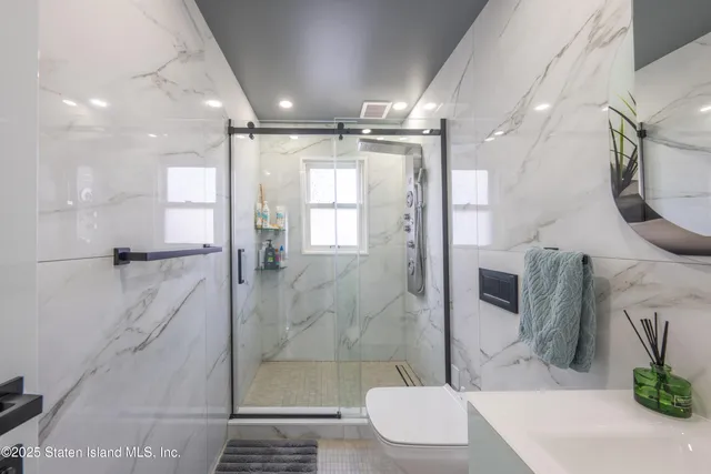 a bathroom with a sink a toilet and shower