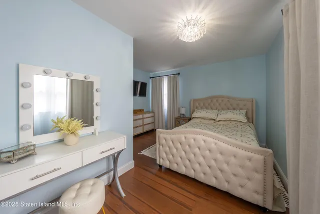 a bedroom with a bed and dresser with mirror