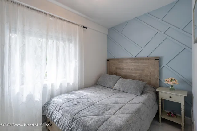 a bedroom with a bed a window and a fireplace