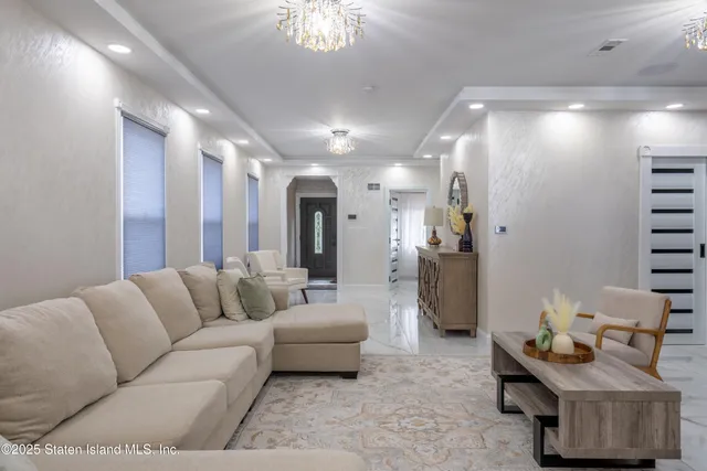 a living room with furniture and a chandelier