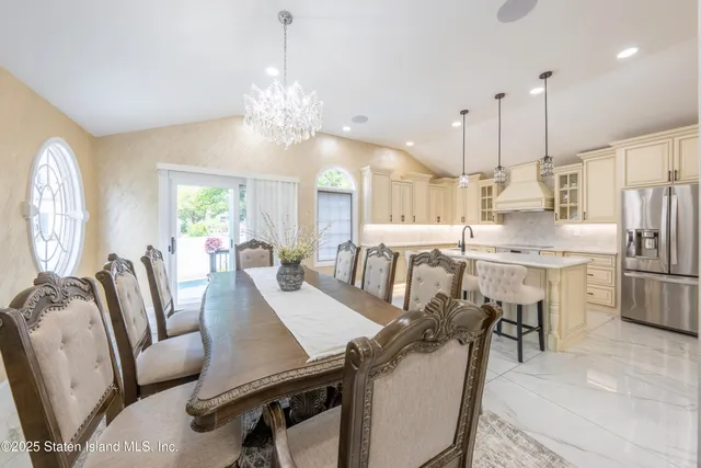 a view of a dining room and livingroom with furniture wooden floor a chandelier