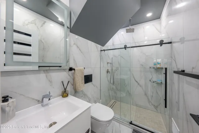 a bathroom with a sink a toilet and shower