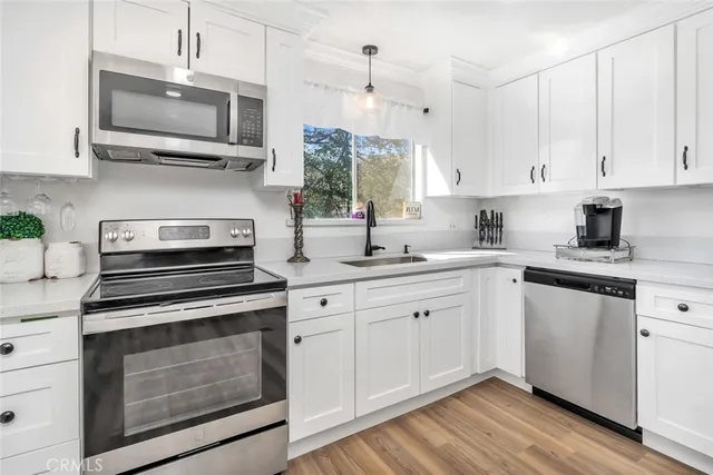 a kitchen with stainless steel appliances a stove sink and microwave