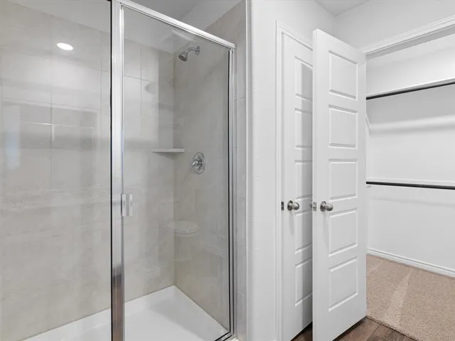 a bathroom with a shower and a glass door