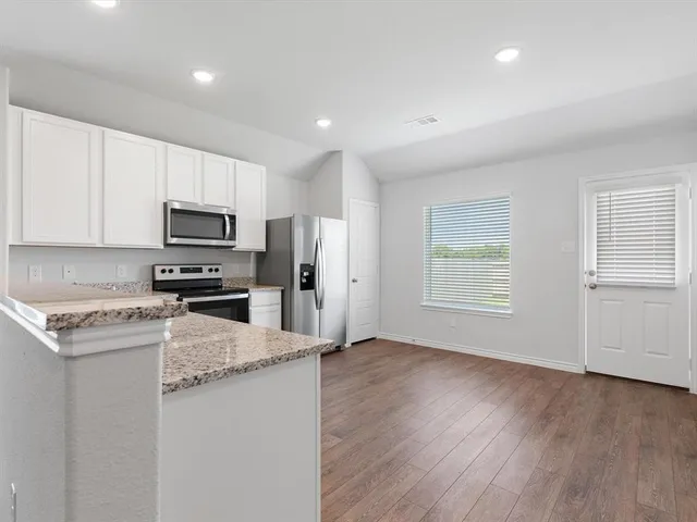 a kitchen with granite countertop a sink stainless steel appliances and cabinets