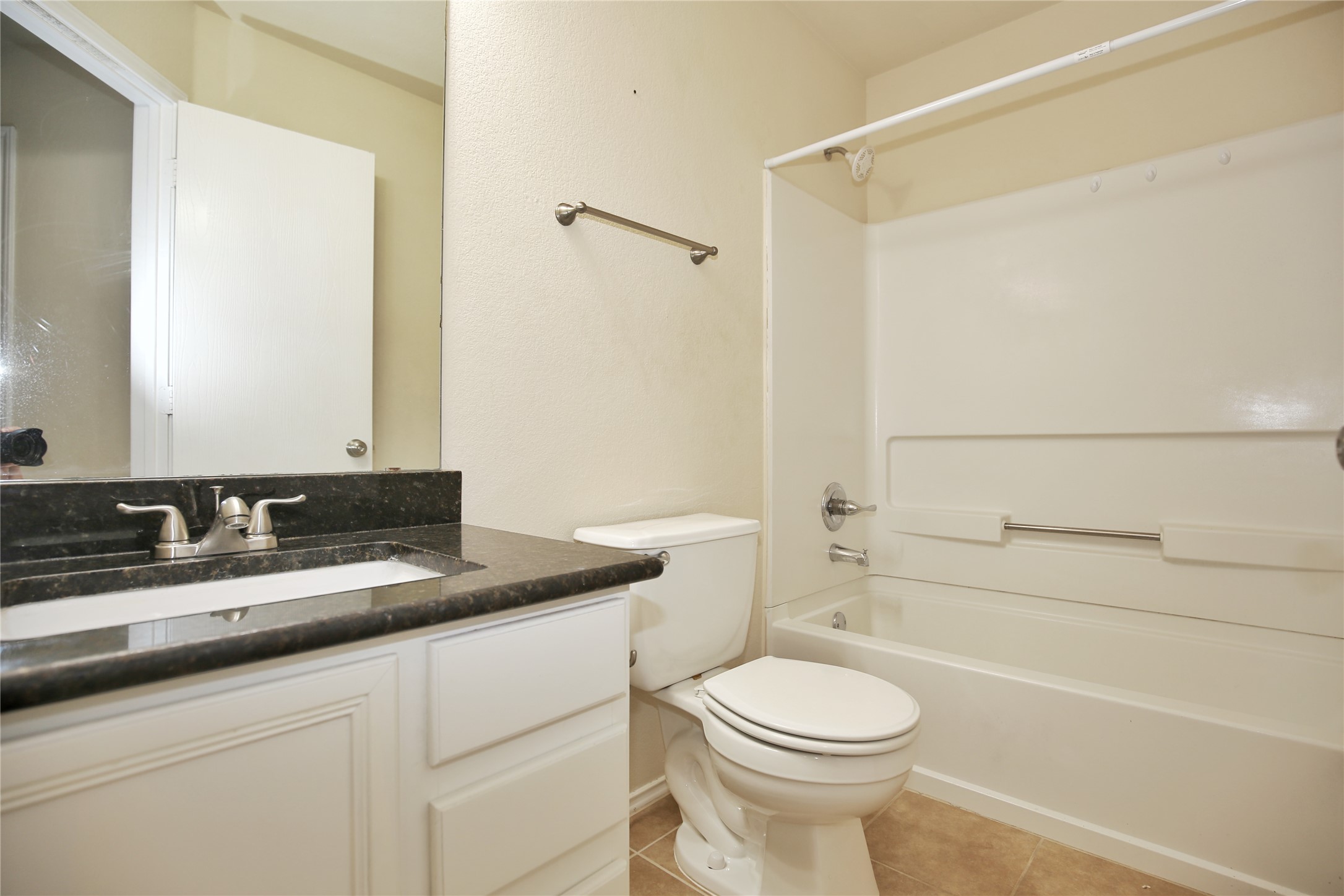 213 Rim Rock Drive Leander, TX 78641 - Photo 18 of 21 a bathroom with a granite countertop toilet sink and mirror