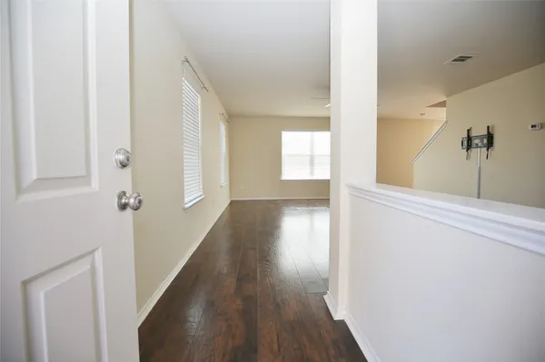 a view of a hallway with wooden floor and staircase