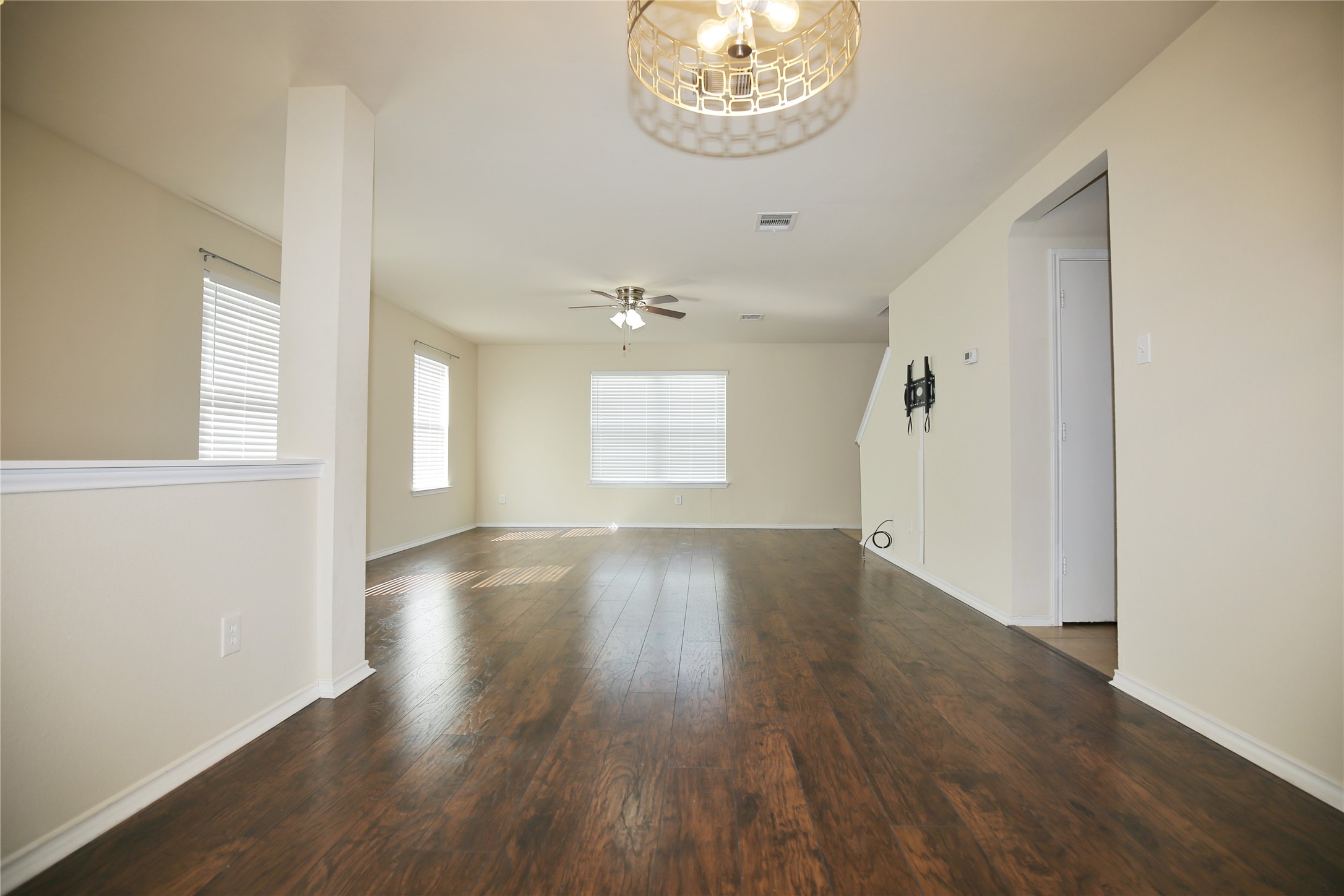 213 Rim Rock Drive Leander, TX 78641 - Photo 5 of 21 an empty room with wooden floor chandelier and windows