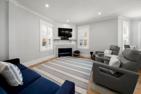 a living room with furniture a flat screen tv and a fireplace