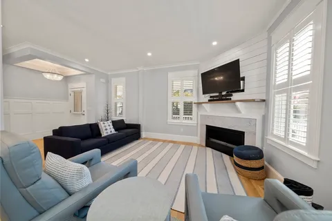 a living room with furniture a fireplace and a flat screen tv