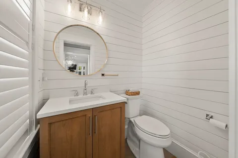 a bathroom with a sink a toilet and mirror