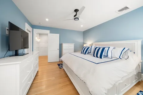 a spacious bedroom with a bed and a flat screen tv