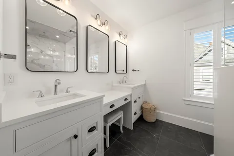 a spacious bathroom with a double vanity sink mirror and window
