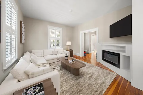 a living room with furniture a fireplace and a flat screen tv