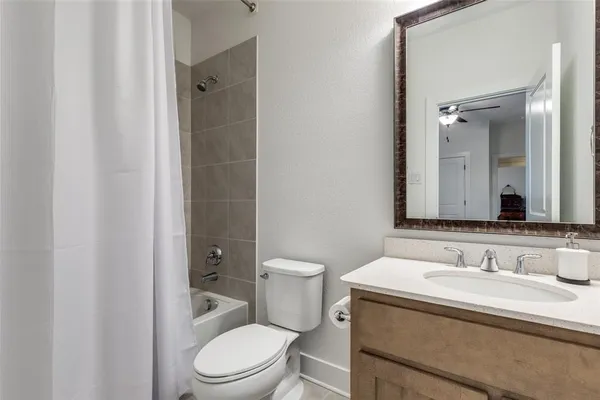 a bathroom with a granite countertop toilet a sink and a mirror