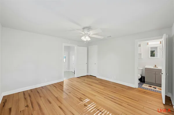a view of a livingroom with wooden floor and a ceiling fan
