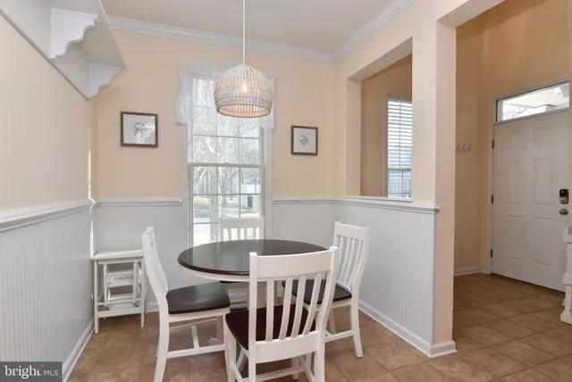 a dining room with furniture a chandelier and window
