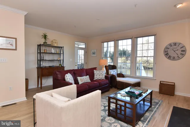 a living room with furniture a bookshelf and a window