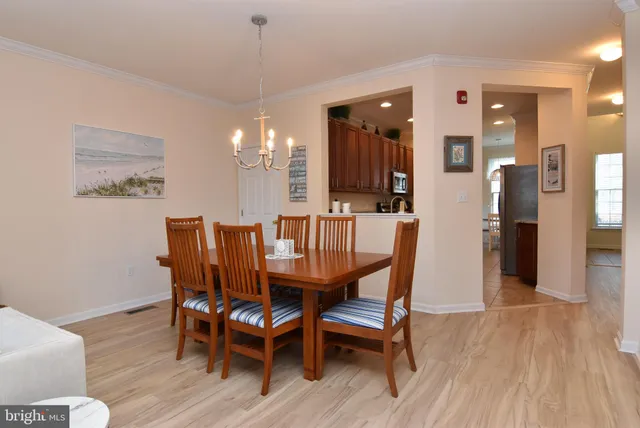 a dining room with furniture a chandelier and wooden floor