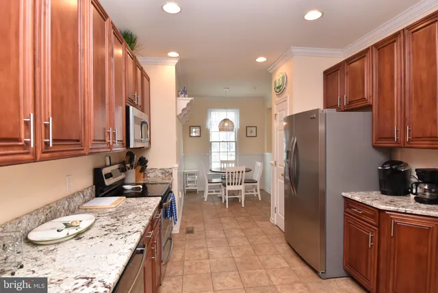 a kitchen with stainless steel appliances granite countertop a refrigerator a sink a stove and island