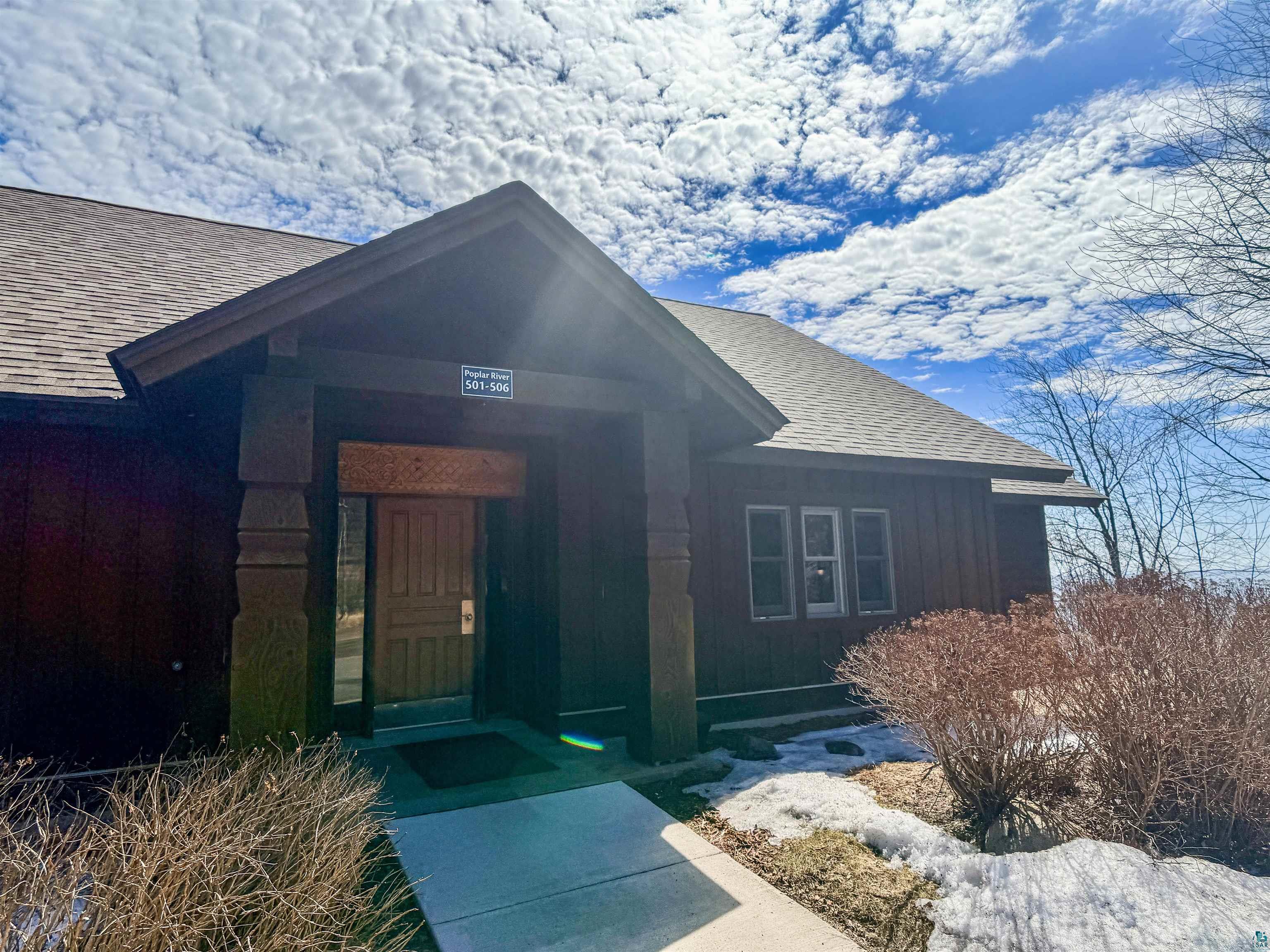 Brown wood-paneled exterior with a prominent covered entry
