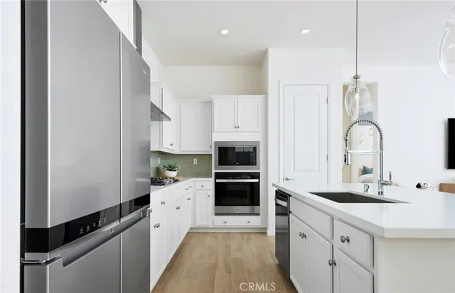 a kitchen with white cabinets and appliances