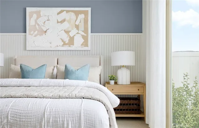 a bedroom with a bed and a painting on the wall