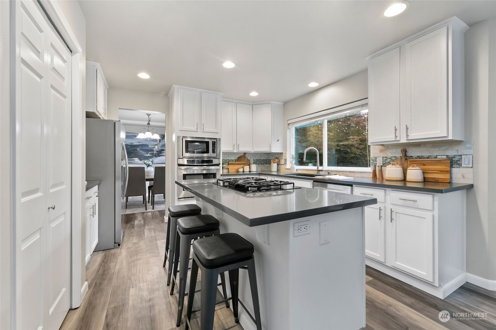 2726 236th Street Southeast Bothell, WA 98021 - Photo 8 of 37 a kitchen with kitchen island granite countertop a sink a stove a refrigerator cabinets and chairs