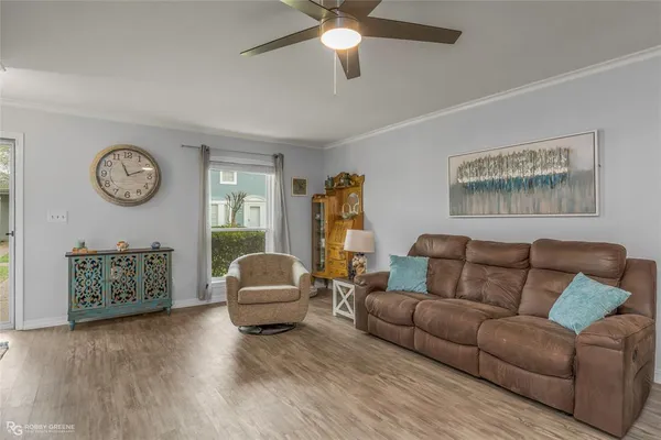 a living room with furniture a clock and a ceiling fan