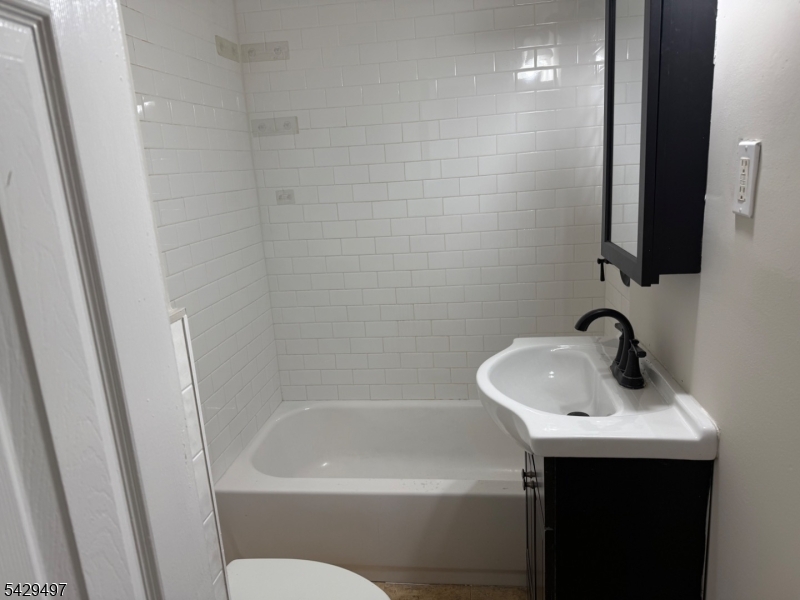 85 Holsman Street Paterson, NJ 07522 - Photo 11 of 20 a bathroom with a sink and a mirror