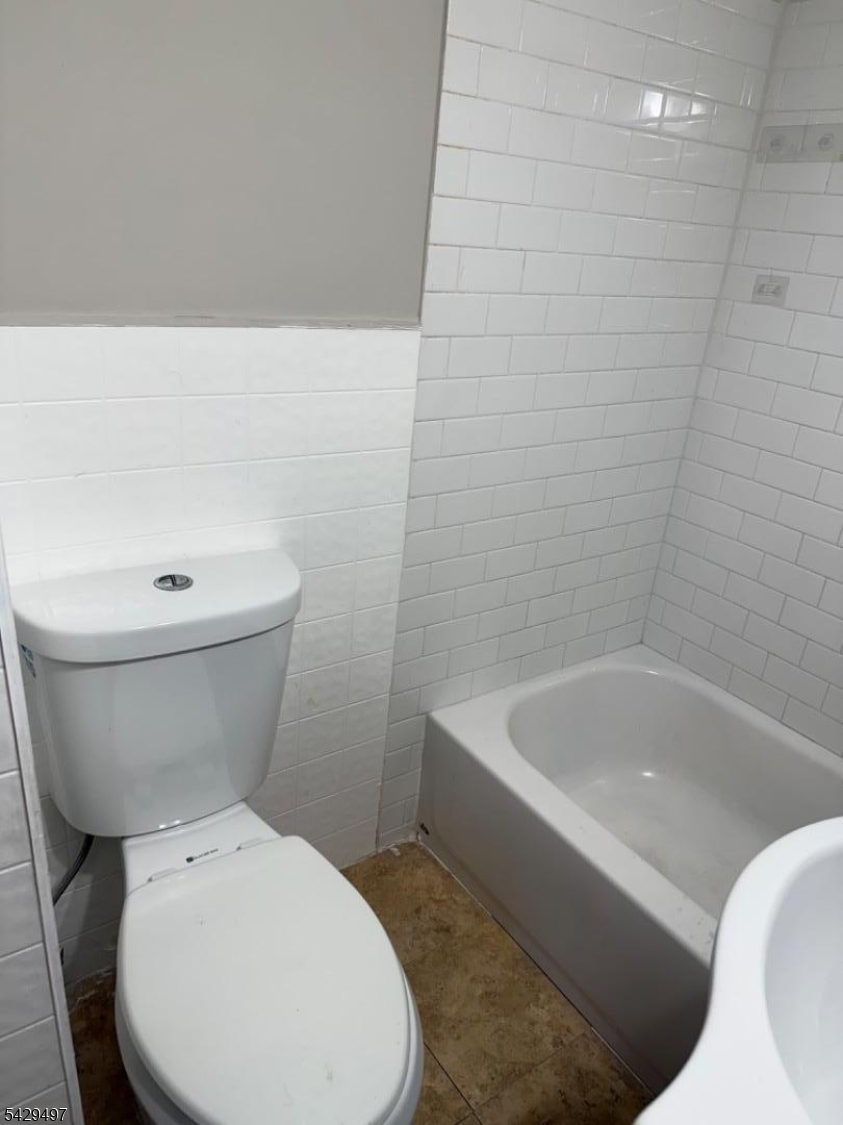 85 Holsman Street Paterson, NJ 07522 - Photo 13 of 20 a white toilet sitting next to a white bath tub