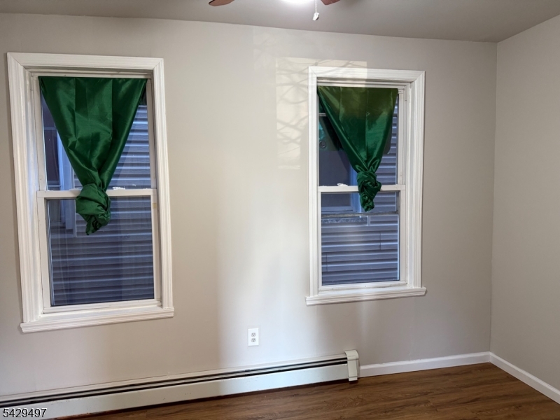 85 Holsman Street Paterson, NJ 07522 - Photo 14 of 20 a view of a hallway with wooden floor and a window