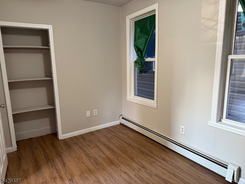 85 Holsman Street Paterson, NJ 07522 - Photo 15 of 20 a view of an empty room with wooden floor and a window