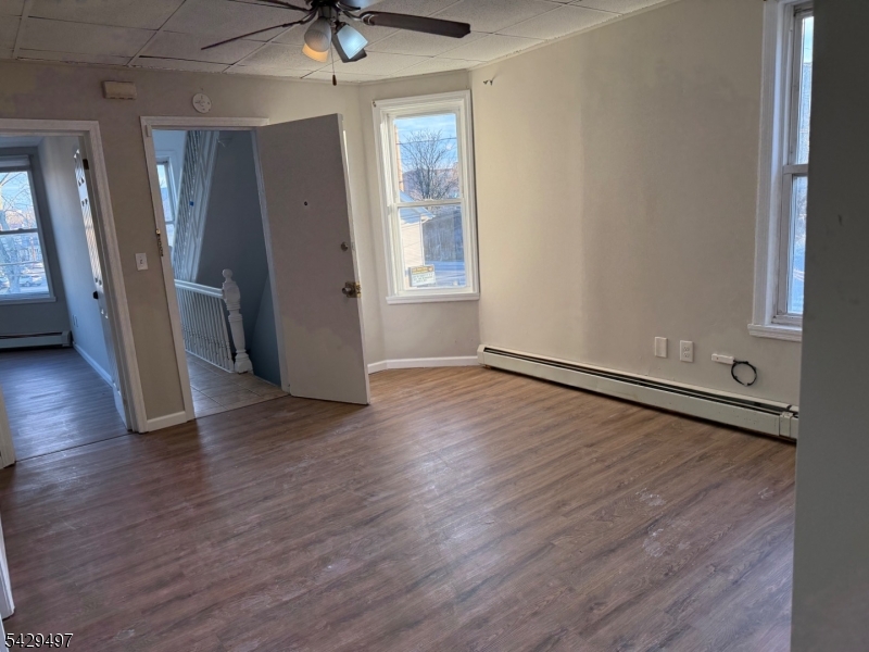 85 Holsman Street Paterson, NJ 07522 - Photo 3 of 20 wooden floor in an empty room with a window