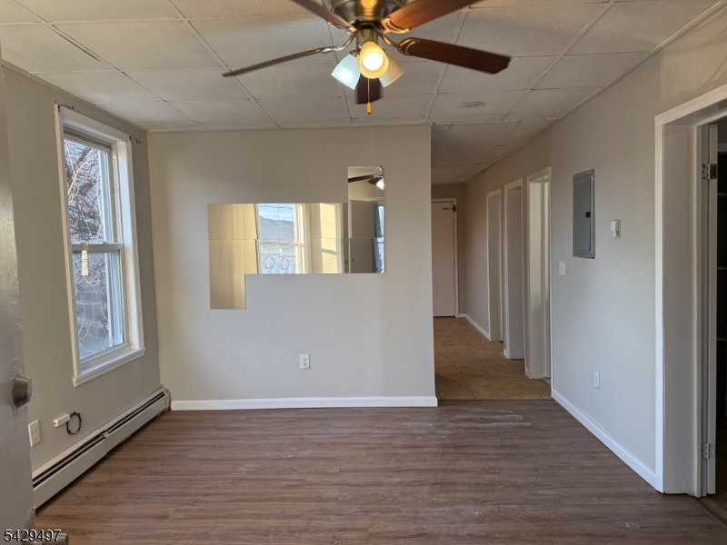 85 Holsman Street Paterson, NJ 07522 - Photo 4 of 20 a view of an empty room with window and wooden floor