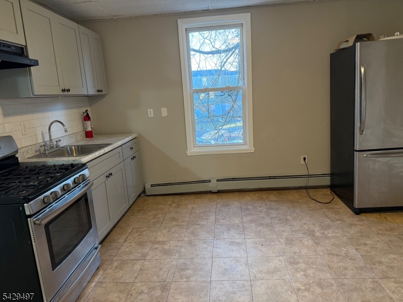 85 Holsman Street Paterson, NJ 07522 - Photo 7 of 20 a kitchen with a refrigerator stove and cabinets