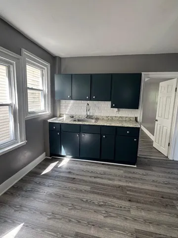 a kitchen with kitchen island granite countertop a sink and wooden cabinets