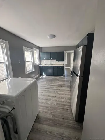 a kitchen with stainless steel appliances a refrigerator sink and wooden floor