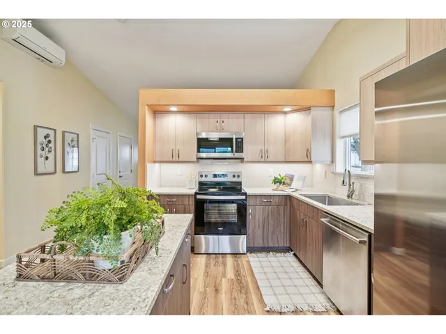 a kitchen with stainless steel appliances kitchen island granite countertop a stove a sink and a refrigerator