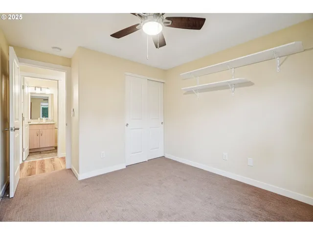 a view of a room with a ceiling fan and hardwood floor