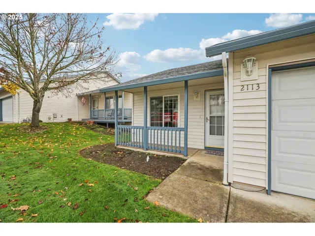 a view of a house with a yard and large tree