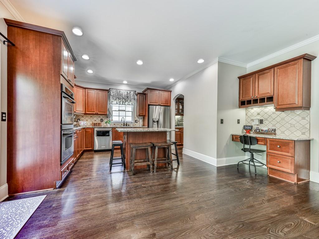619 Riverbend Way Canton, GA 30114 - Photo 14 of 76 a kitchen with stainless steel appliances kitchen island granite countertop a refrigerator a stove a sink a dining table and chairs with wooden floor