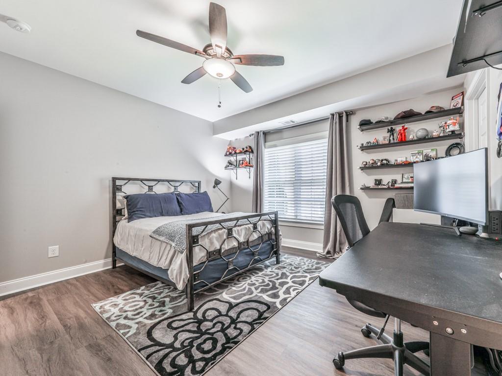 619 Riverbend Way Canton, GA 30114 - Photo 49 of 76 a bedroom with a bed a desk and chair with wooden floor