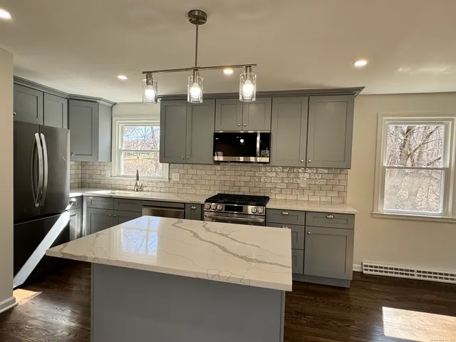 a kitchen with a sink a counter top space stainless steel appliances and cabinets