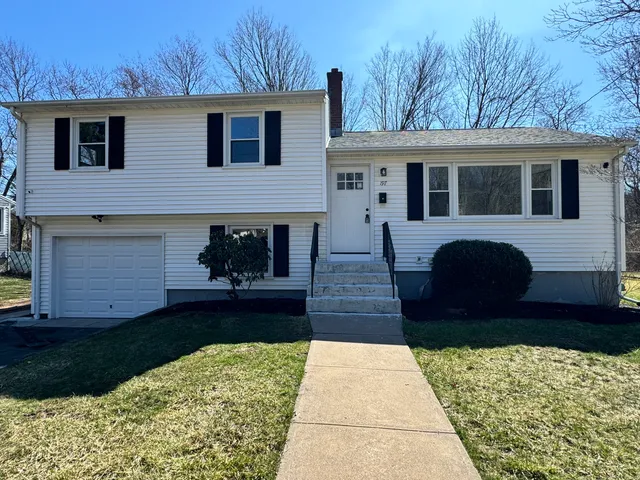 a front view of a house with a garden and yard