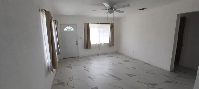 an empty room that has a window and a hallway